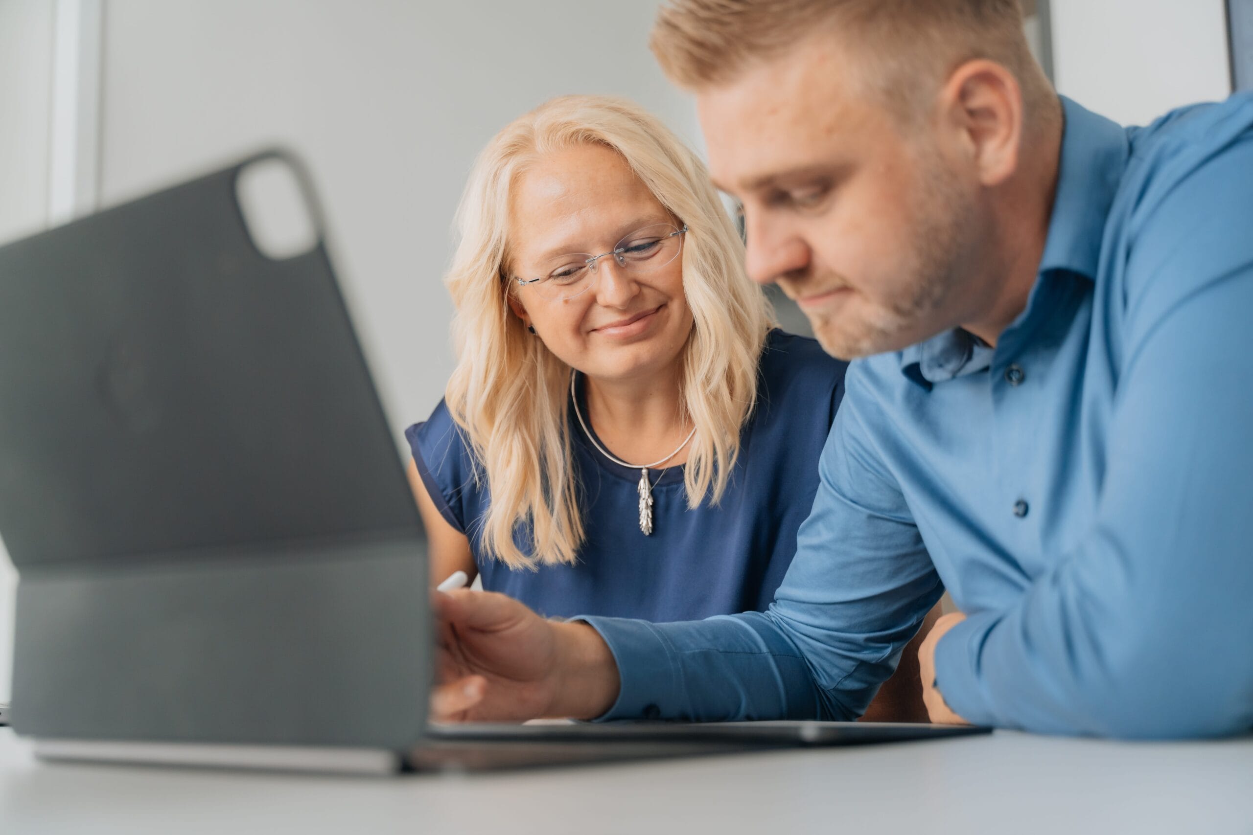 Alexander und Justine Reith schauen gemeinsam auf ein iPad während einer Strategie-Sitzung bei reith.marketing
