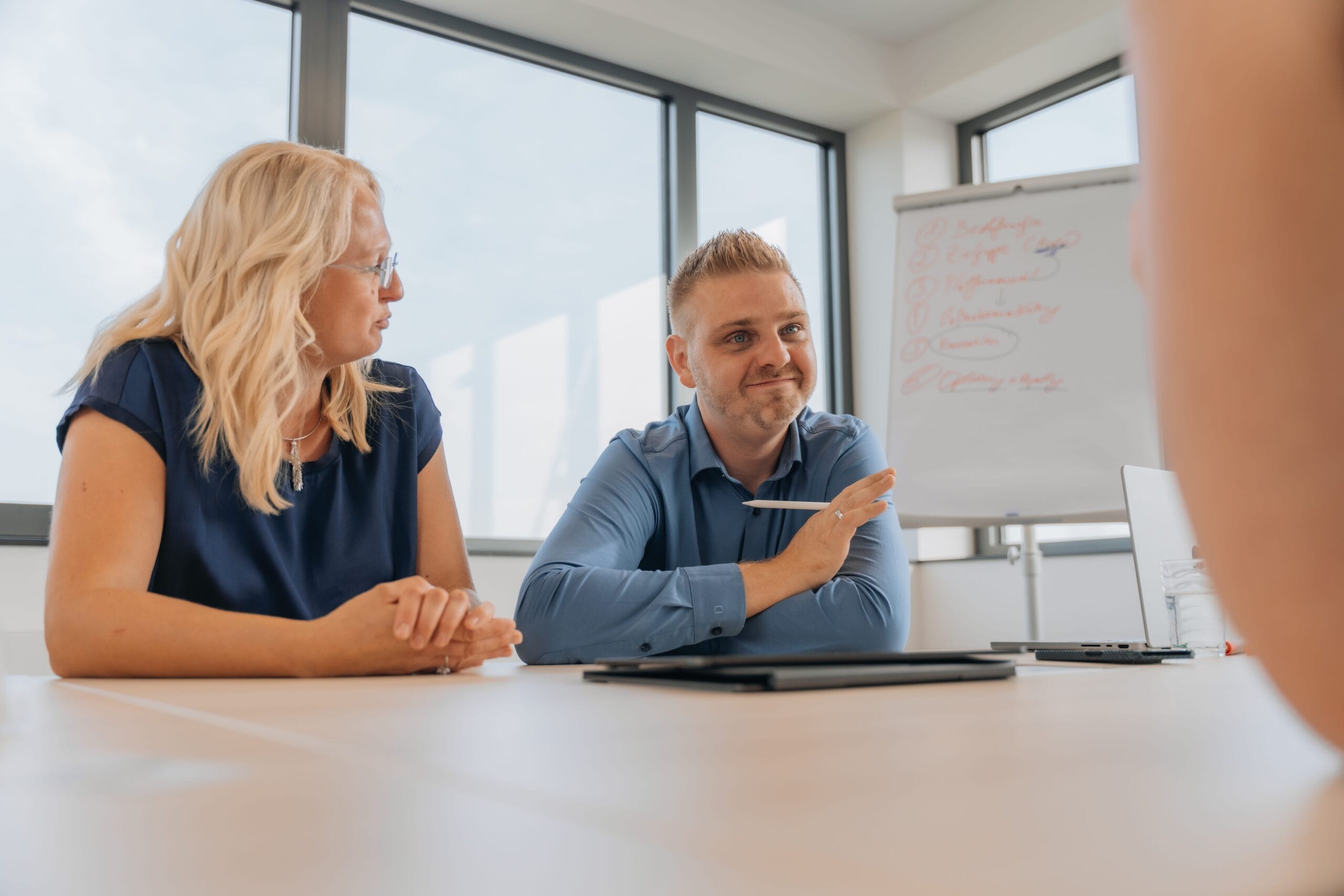 Alexander und Justine Reith im Kundenmeeting bei reith.marketing, am Besprechungstisch mit Flipchart im Hintergrund
