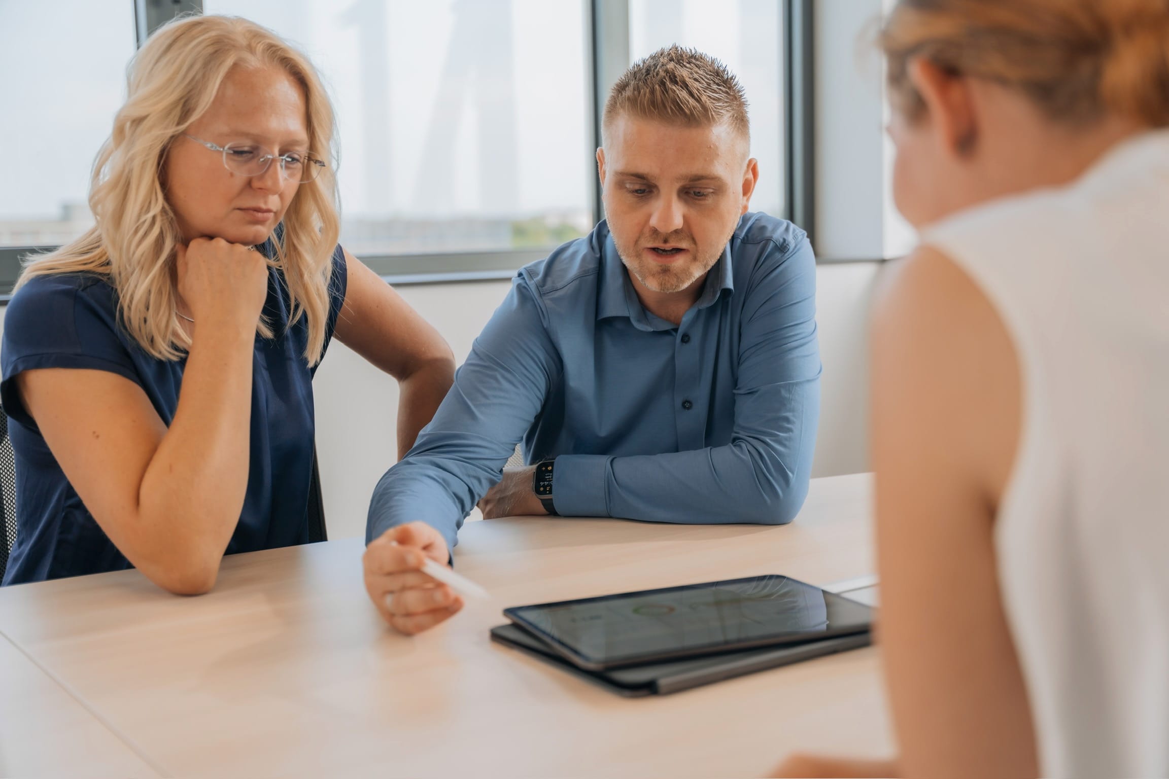 Alexander und Justine Reith im Strategiegespräch mit einer Kundin bei reith.marketing, gemeinsam am iPad